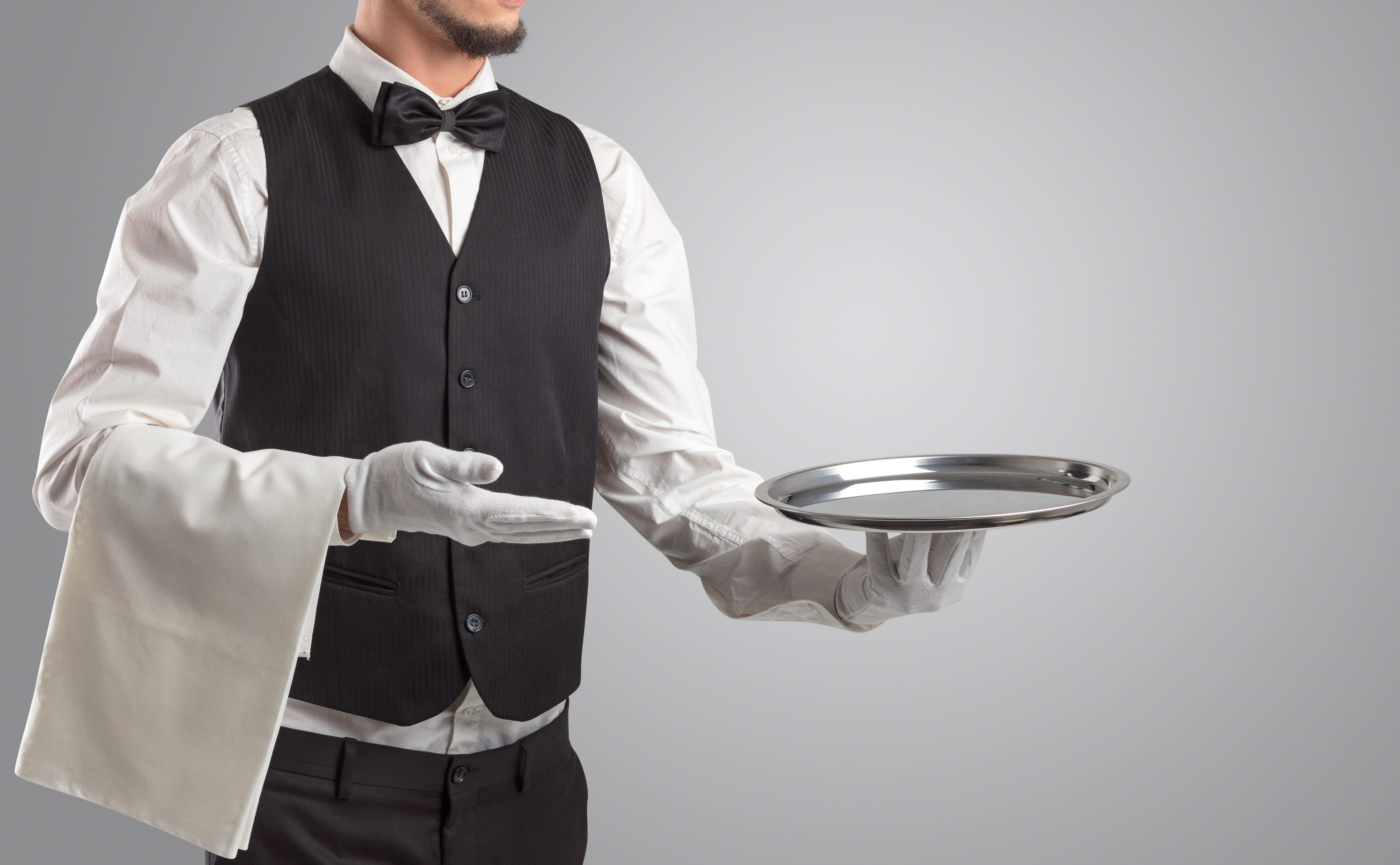 Varias charolas de mesero de acero inoxidable distintas exhibidas en una mesa de madera, resaltando la diversidad de bandejas de acero utilizadas en la industria restaurantera. | EdeComercial